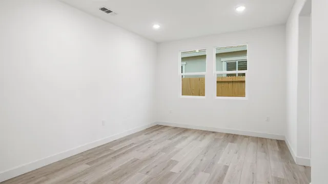 an empty room with a window and wooden floor