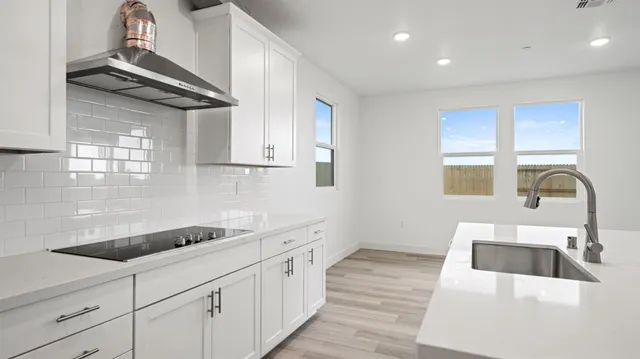 a kitchen with granite countertop a sink stainless steel appliances and cabinets