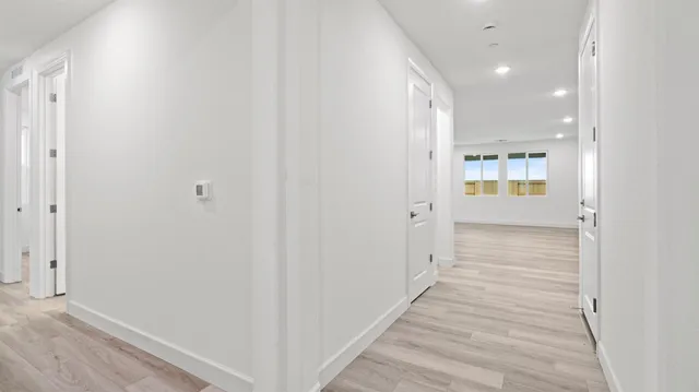 a view of a hallway with wooden floor
