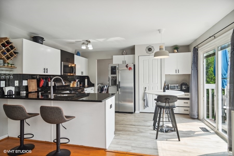 440 Spaulding Road Bartlett, IL 60103 - Photo 6 of 27 a kitchen with stainless steel appliances kitchen island granite countertop a refrigerator and cabinets