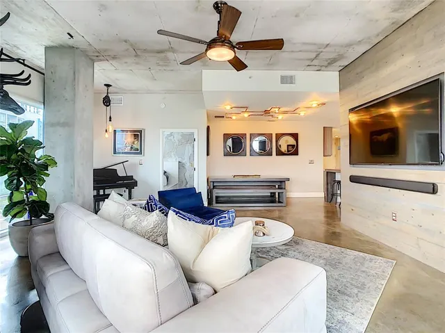 a living room with furniture a flat screen tv and kitchen view