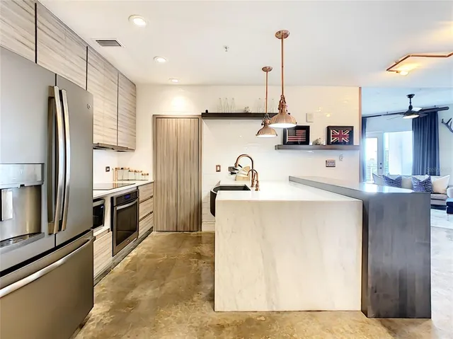 a kitchen with kitchen island a sink appliances and cabinets