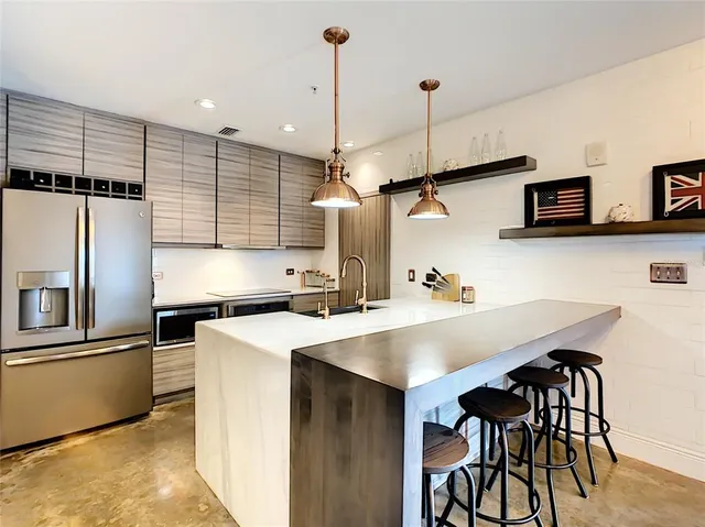 a kitchen with stainless steel appliances granite countertop a sink a stove and a wooden floor