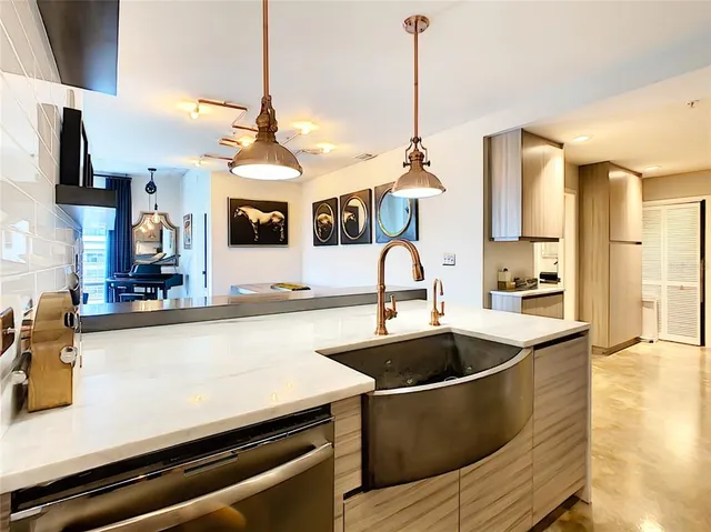 a kitchen with stainless steel appliances granite countertop a sink a microwave cabinets and a dining table