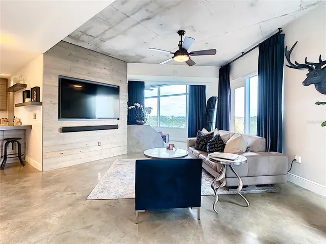 a living room with patio furniture and a chandelier