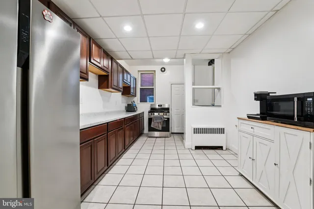 a large white kitchen with a sink and dishwasher a stove with wooden floor