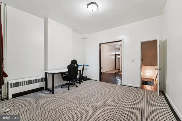 a view of a bedroom with a bed and wooden floor