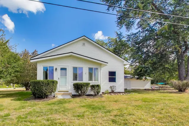 a view of a house with a big yard and potted plants