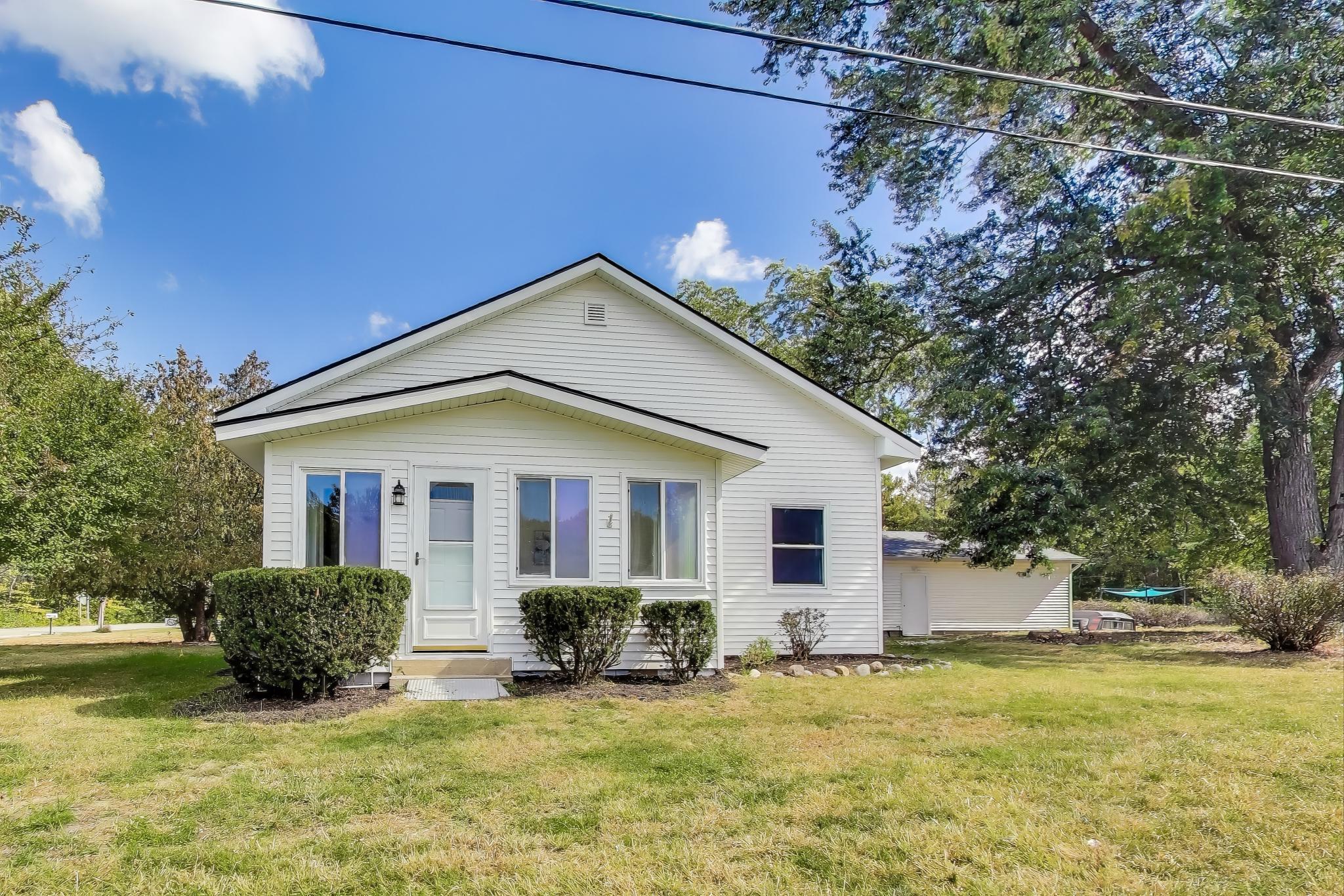 a view of a house with a big yard and potted plants