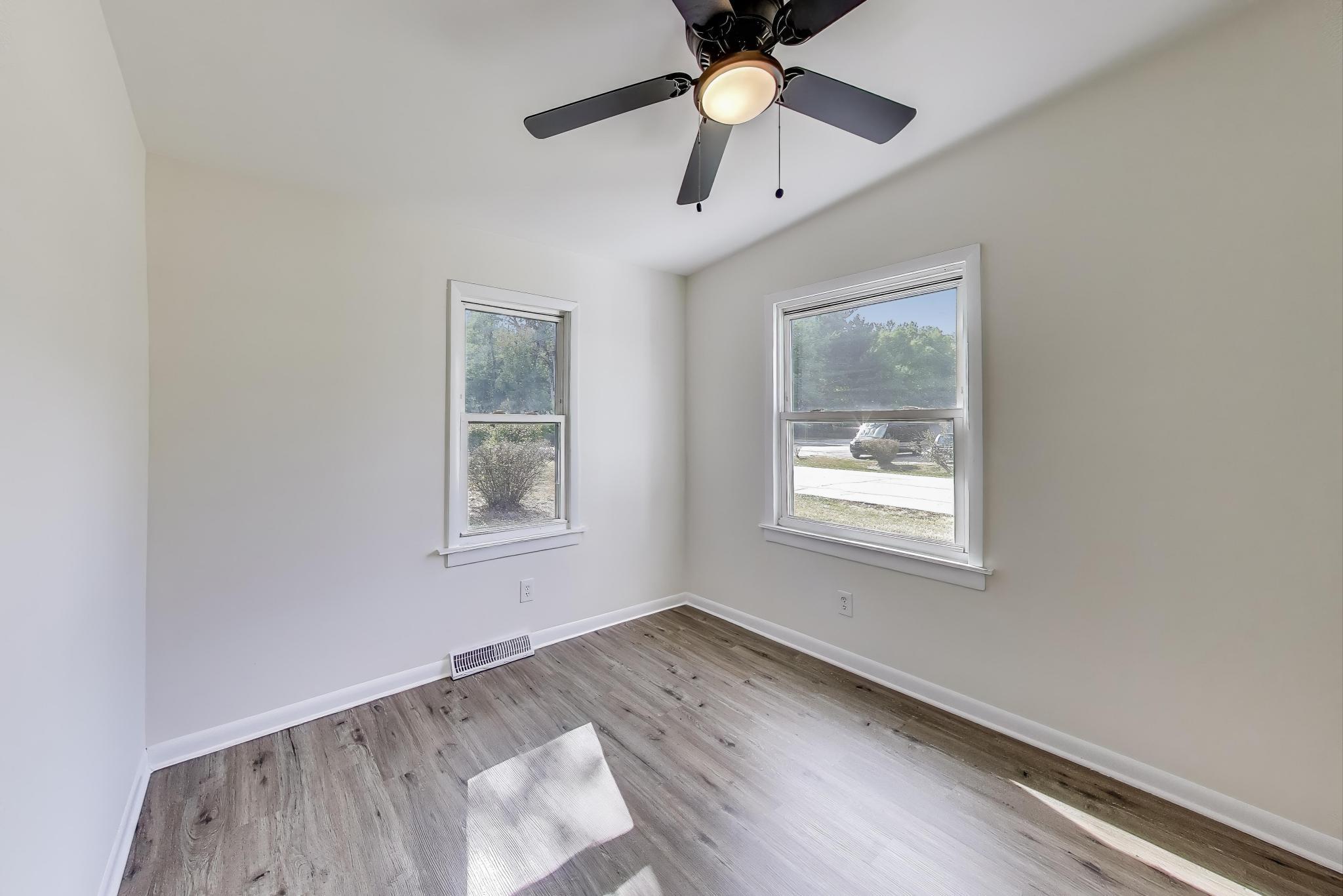102 South Karwick Road Michigan City, IN 46360 - Photo 13 of 30 an empty room with wooden floor ceiling fan and windows