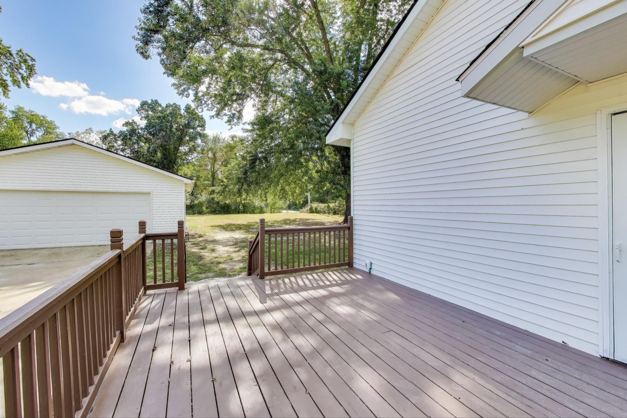 102 South Karwick Road Michigan City, IN 46360 - Photo 22 of 30 a view of a deck with wooden floor and fence next to a yard