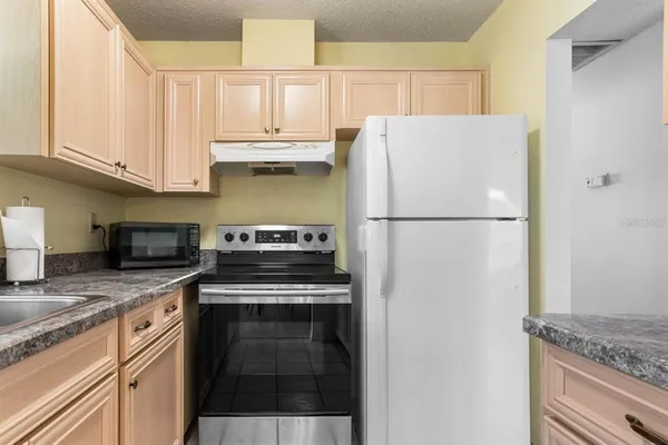a kitchen with appliances cabinets and a counter top space