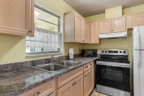 a kitchen with a sink stove top oven and cabinets