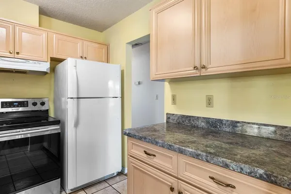 a kitchen with granite countertop a refrigerator a stove and a sink