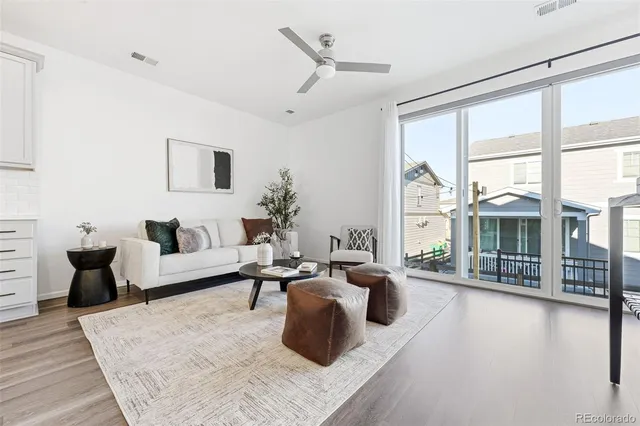 a living room with furniture wooden floor and a large window