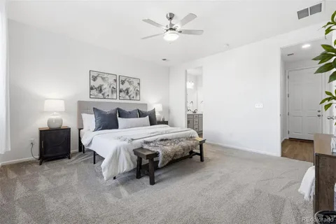 a spacious bedroom with a bed and a chandelier