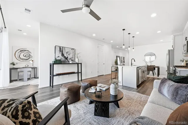 a living room with furniture and a wooden floor