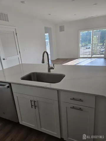 a kitchen with granite countertop a sink and stainless steel appliances