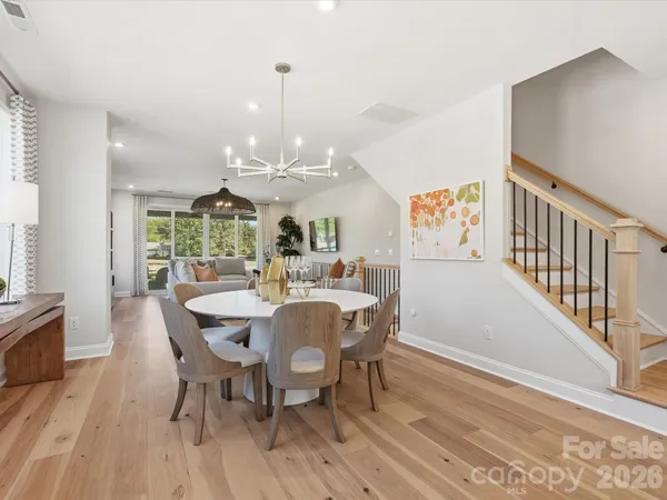 a view of a dining room with furniture a chandelier and wooden floor