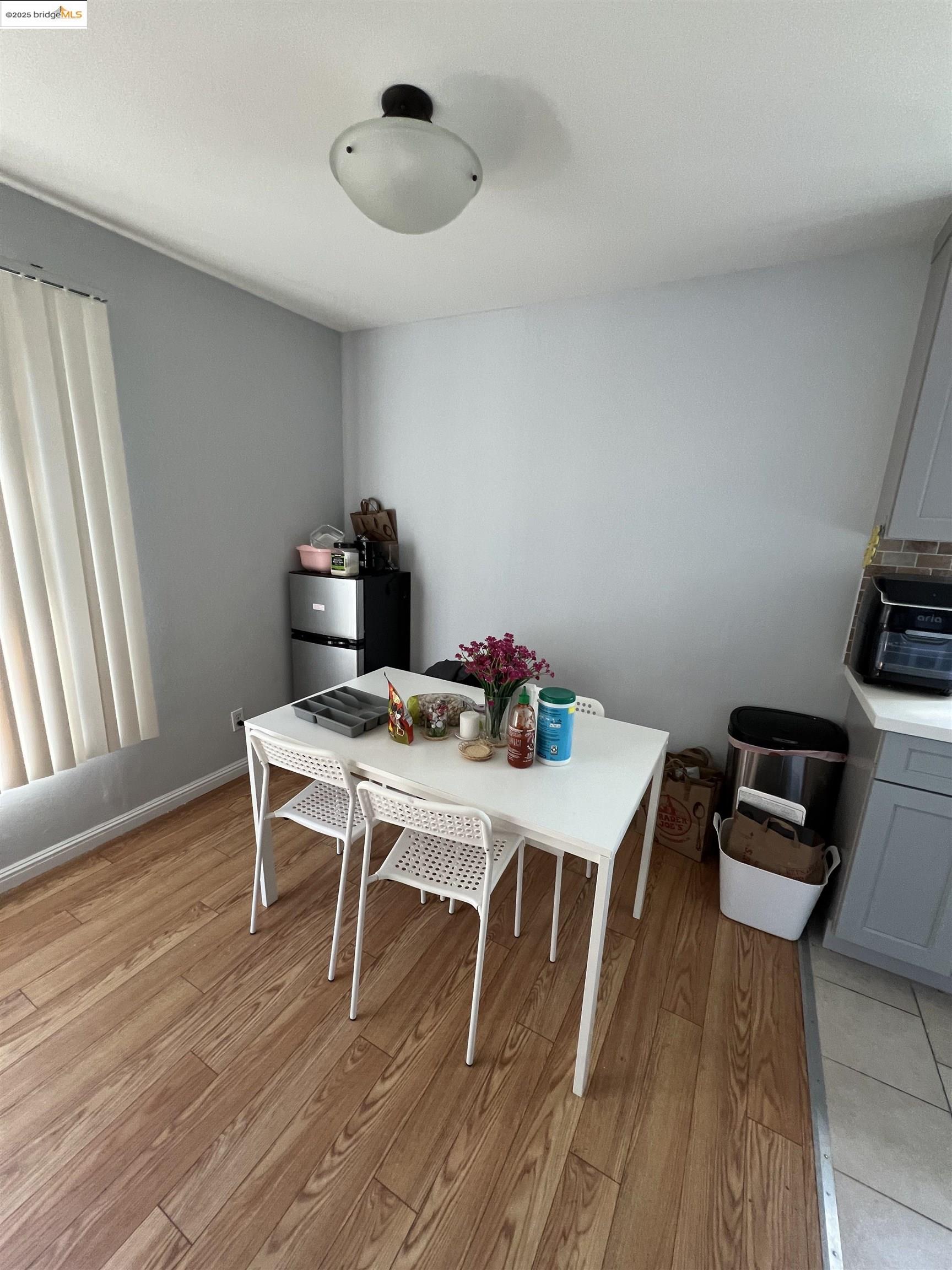 2636 Warring Street, Unit 305 Berkeley, CA 94704 - Photo 3 of 8 a workspace with furniture wooden floor and a window