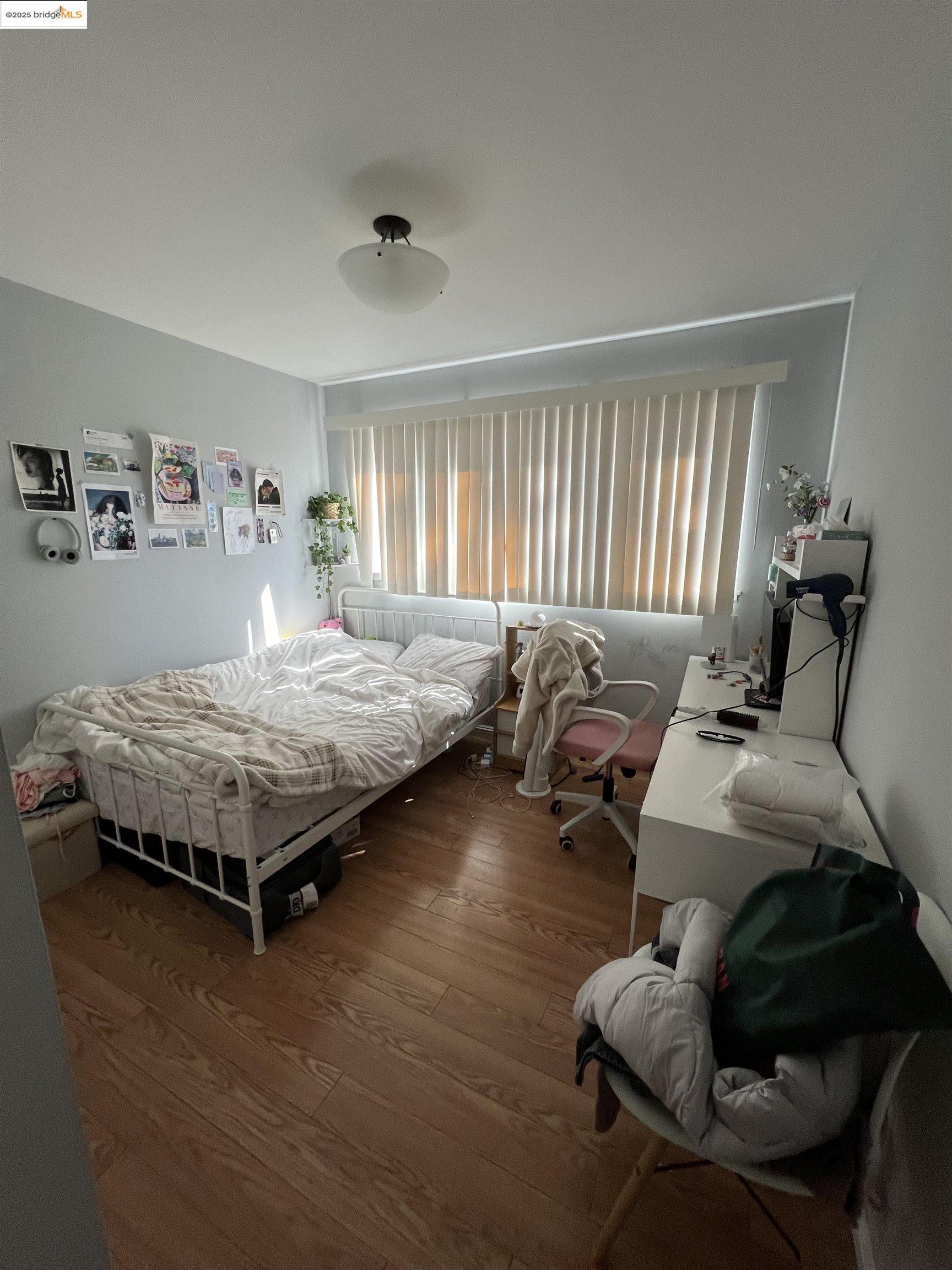 2636 Warring Street, Unit 305 Berkeley, CA 94704 - Photo 5 of 8 a bedroom with a bed and wooden floor