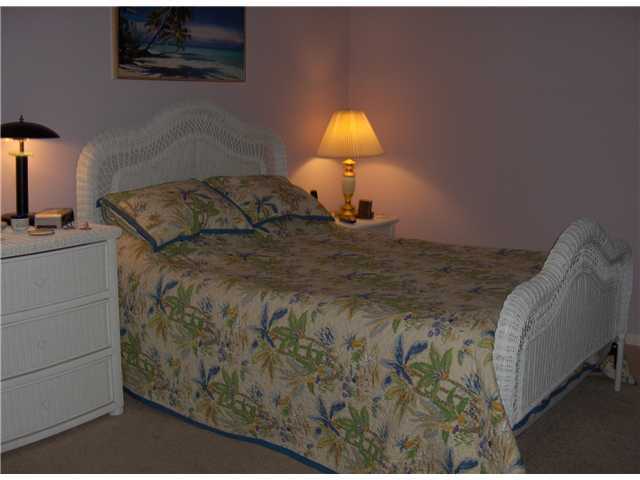367 River Edge Road Jupiter, FL 33477 - Photo 6 of 17 a bed sitting in a bedroom next to a lamp