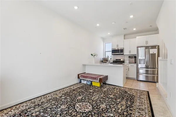 a kitchen with stainless steel appliances kitchen island granite countertop a refrigerator and a stove top oven