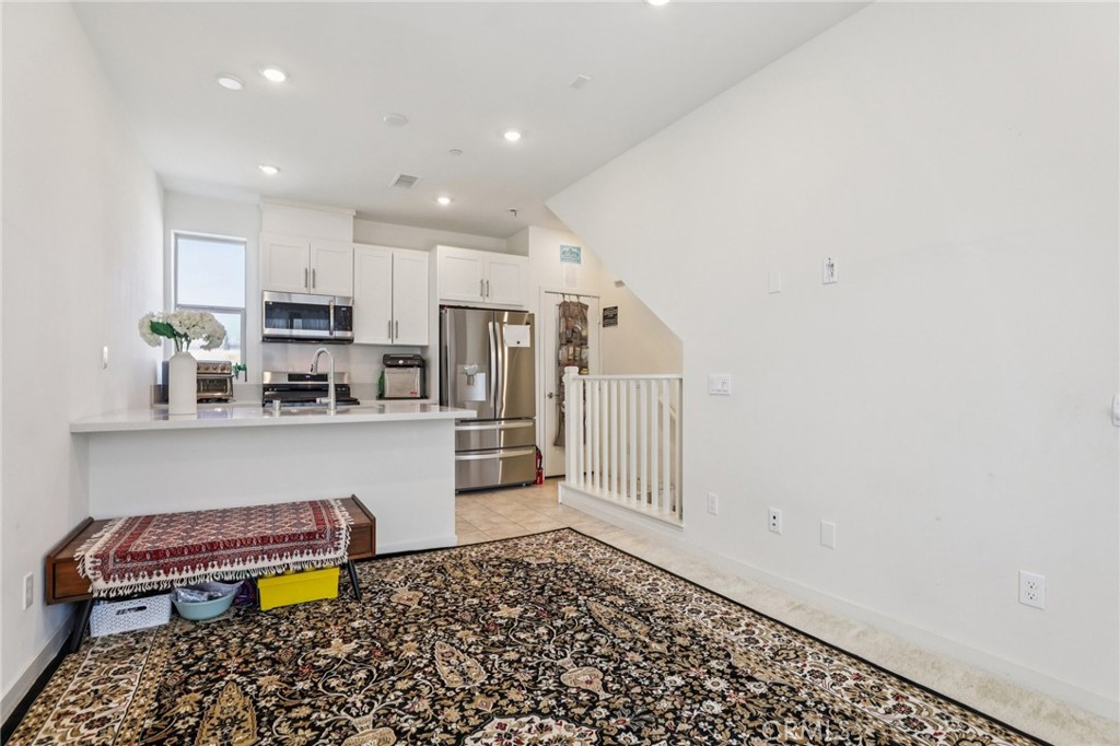 1571 Lima Way, Unit 5 Placentia, CA 92870 - Photo 6 of 21 a kitchen with stainless steel appliances kitchen island granite countertop a refrigerator and a stove top oven