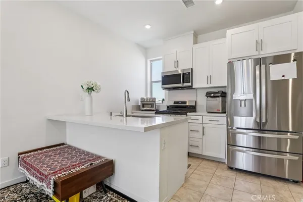 a kitchen with stainless steel appliances a refrigerator sink and microwave