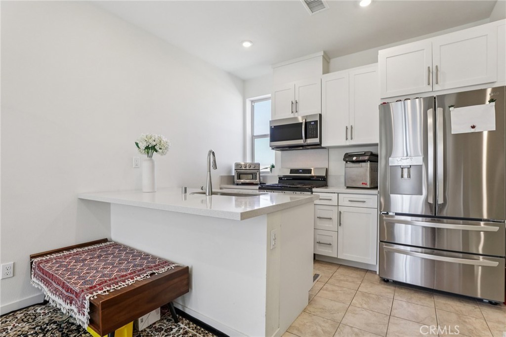 1571 Lima Way, Unit 5 Placentia, CA 92870 - Photo 8 of 21 a kitchen with stainless steel appliances granite countertop a refrigerator sink and microwave