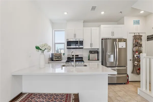 a kitchen with stainless steel appliances white cabinets and a stove top oven