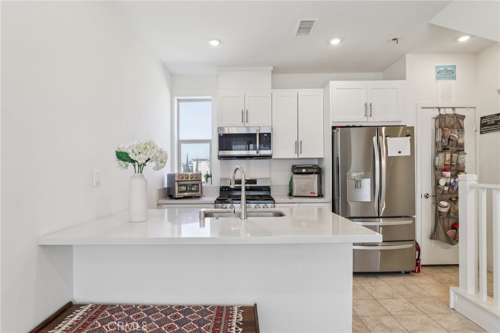 1571 Lima Way, Unit 5 Placentia, CA 92870 - Photo 9 of 21 a kitchen with stainless steel appliances a refrigerator sink and microwave