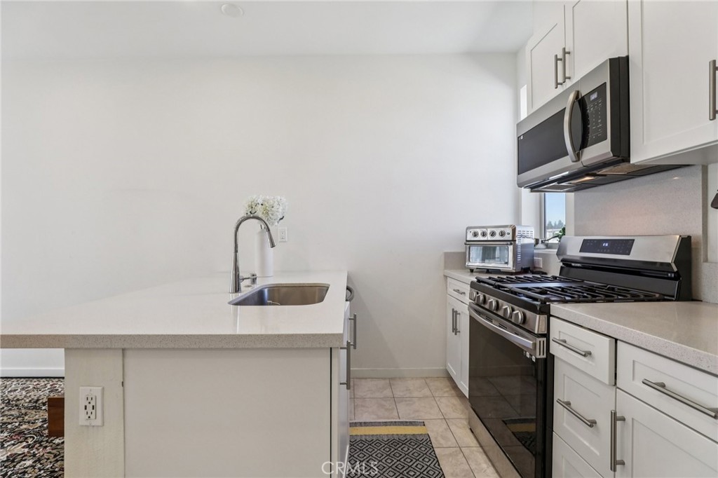 1571 Lima Way, Unit 5 Placentia, CA 92870 - Photo 10 of 21 a kitchen with stainless steel appliances white cabinets and a stove top oven