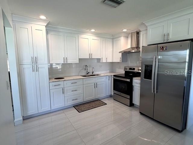1629 Willow Run Sebring, FL 33872 - Photo 4 of 16 a kitchen with white cabinets and stainless steel appliances