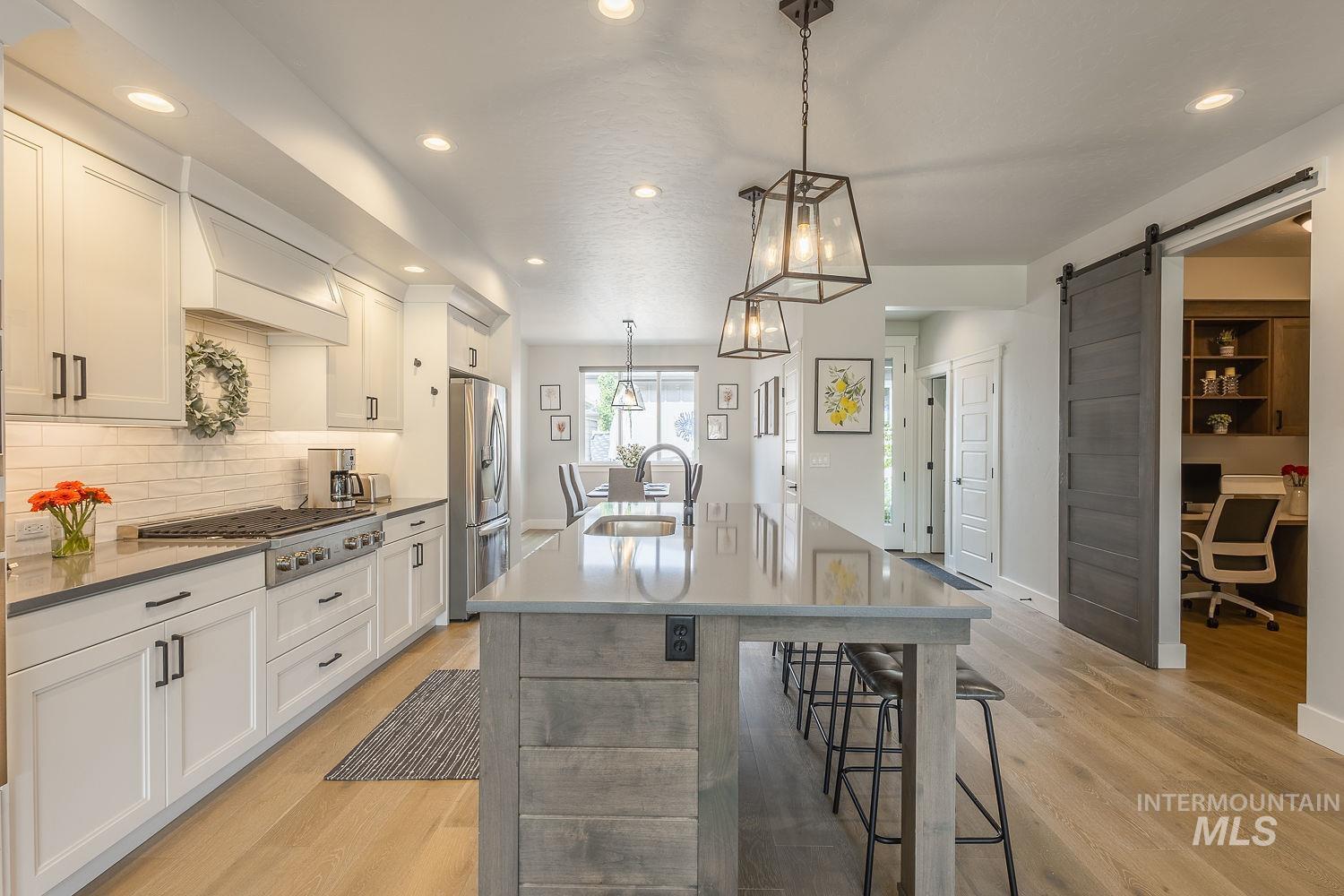 3321 South Hopes Well Way Boise, ID 83716 - Photo 12 of 40 Kitchen with pendant lighting, a breakfast bar area, a center island with sink, a desk, and recessed lighting