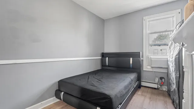 a bedroom with a bed and a refrigerator