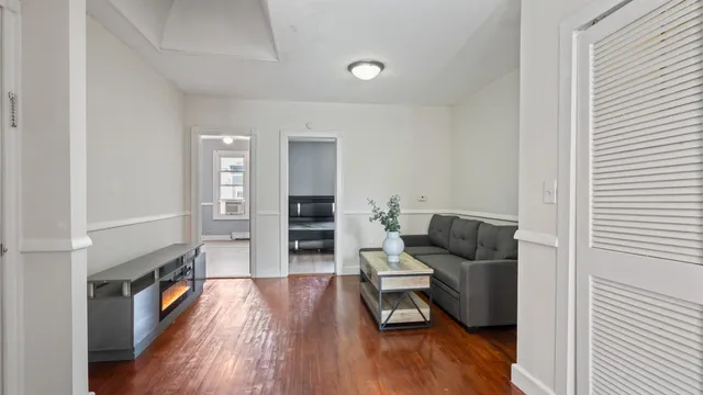 a living room with furniture and hard wood flooring