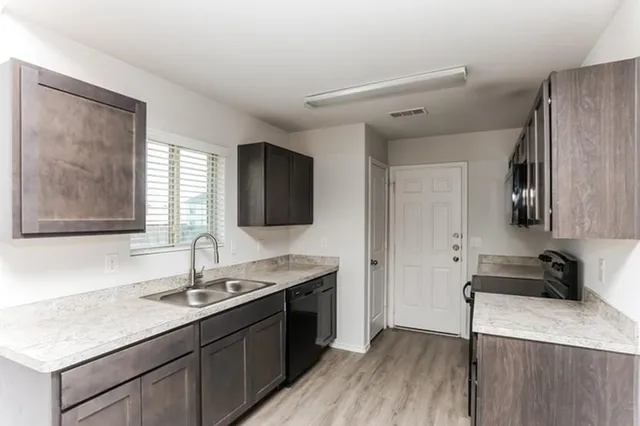a kitchen with a sink appliances and cabinets