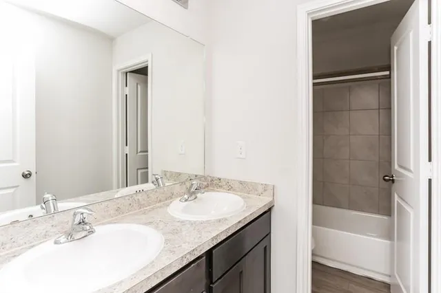 a bathroom with a granite countertop sink and a bathtub