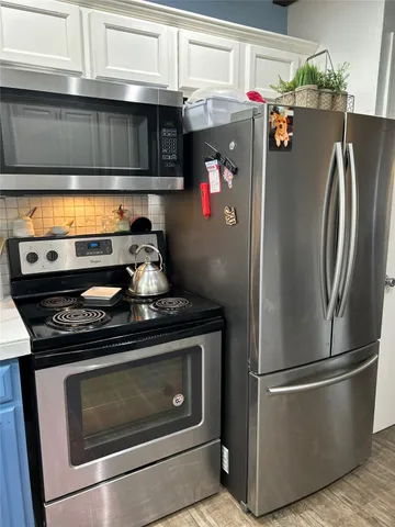 a kitchen with stainless steel appliances granite countertop a refrigerator and a stove