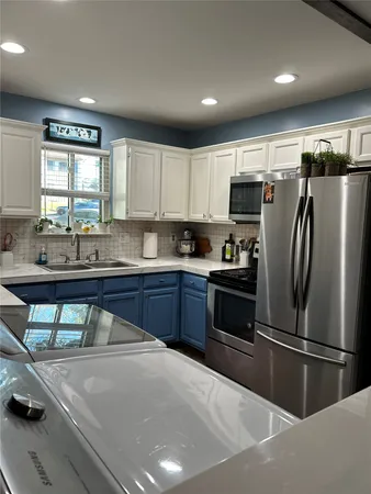 a kitchen with stainless steel appliances a refrigerator sink and cabinets