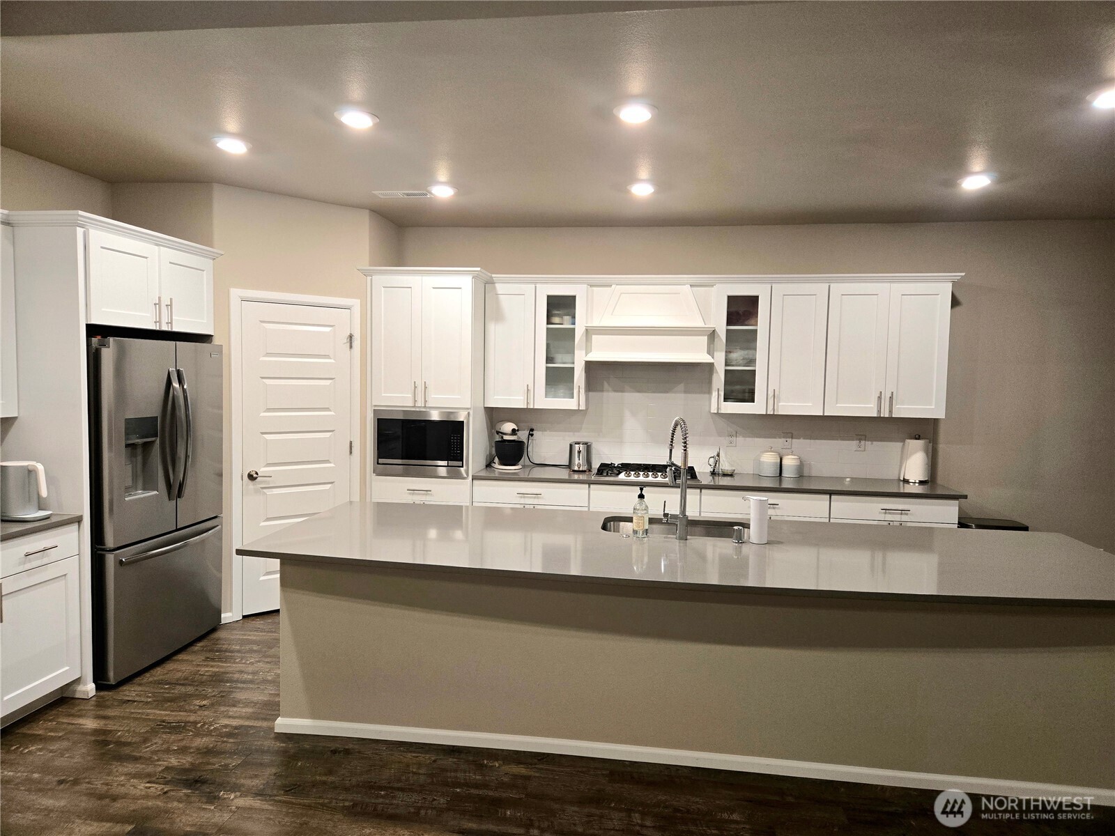 28902 239th Avenue Southeast Maple Valley, WA 98010 - Photo 7 of 22 a large kitchen with granite countertop a refrigerator a sink a stove a microwave and cabinets