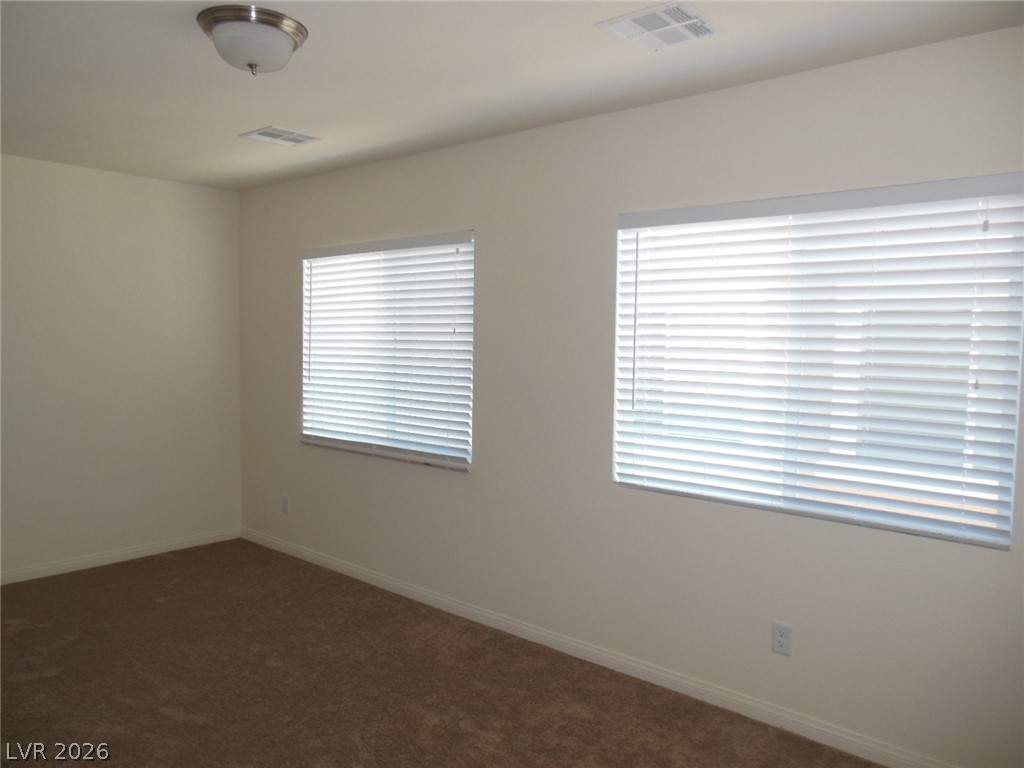 6390 Jackson Spring Road Las Vegas, NV 89118 - Photo 14 of 27 Two well-lit windows with blinds create a bright and comfortable atmosphere.