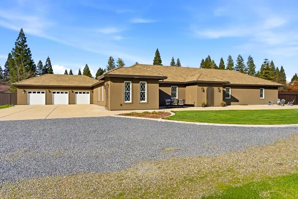 a front view of a house with a yard and potted plants