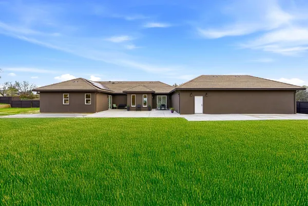 a view of a house with a big yard and potted plants