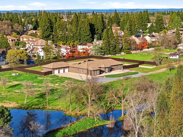an aerial view of a house with backyard space and balcony