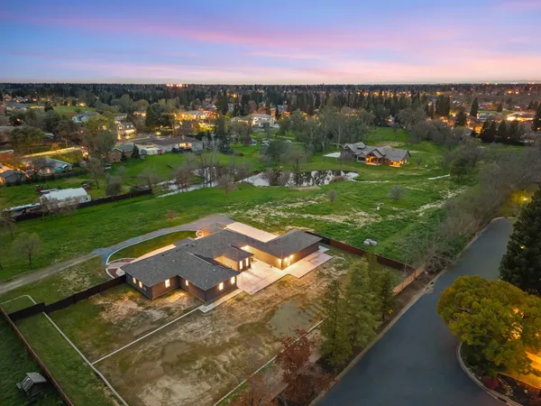 an aerial view of a house with swimming pool garden and patio