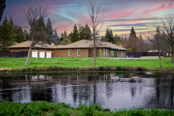 a front view of a house with a garden and yard