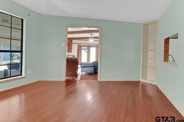 an empty room with windows and fan