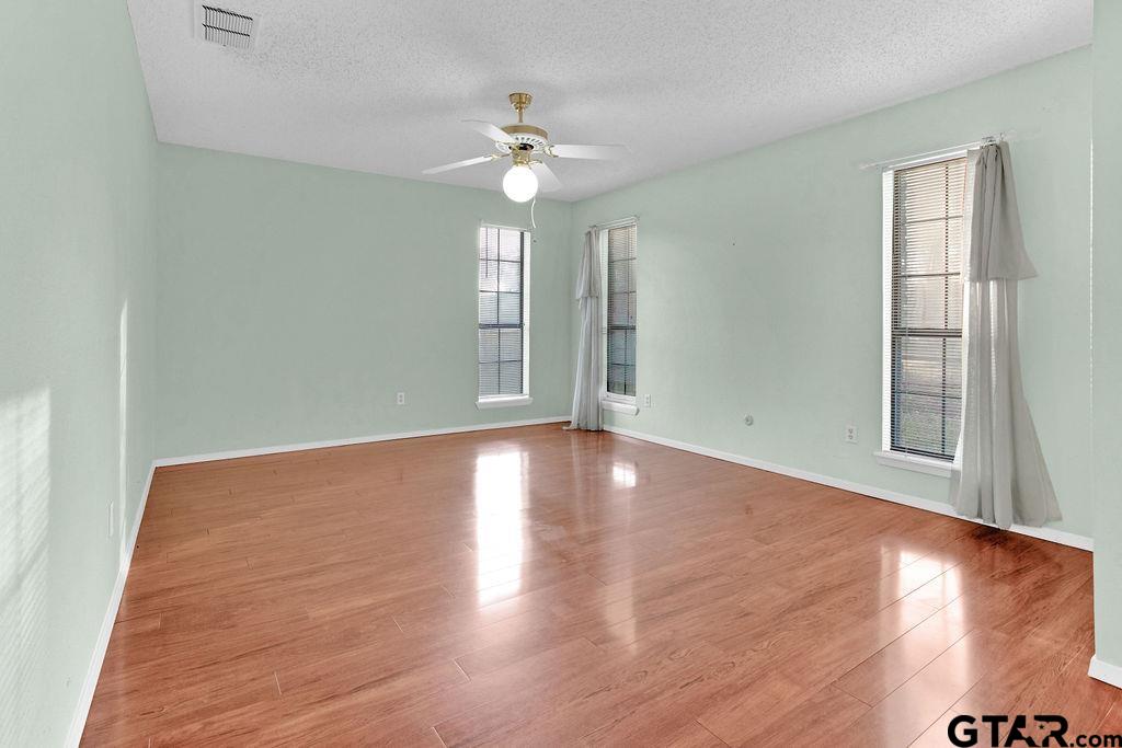 12575 FM 3271 Tyler, TX 75704 - Photo 27 of 47 an empty room with wooden floor chandelier fan and windows